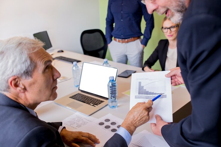 Business professionals discussing data analysis with charts and graphs during a meeting in a modern office setting.