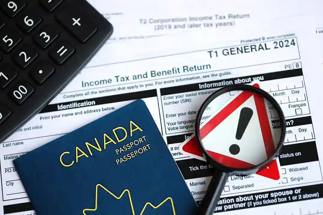 Canada passport alongside income tax return documents and a magnifying glass highlighting an alert symbol, representing tax filing.